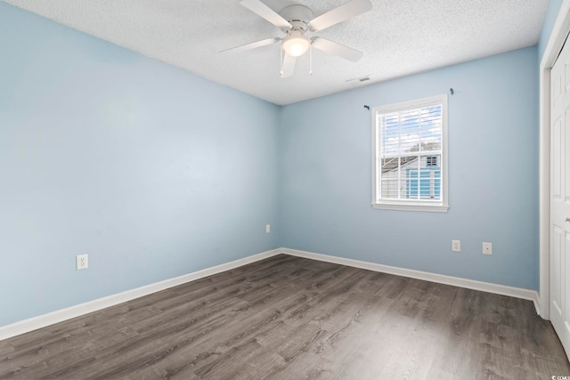 unfurnished room featuring ceiling fan, dark hardwood / wood-style floors, and a textured ceiling