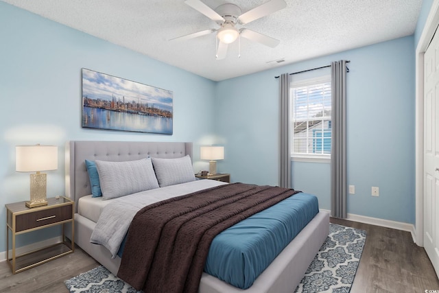 bedroom featuring ceiling fan, wood-type flooring, a closet, and a textured ceiling