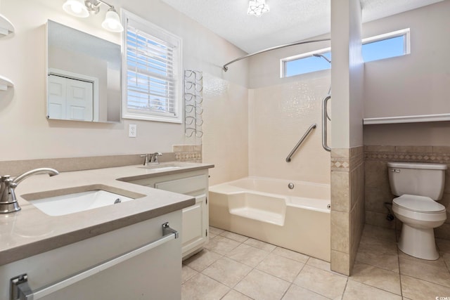 full bathroom with washtub / shower combination, tile patterned floors, toilet, and a textured ceiling