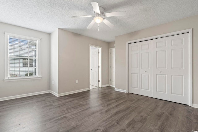 unfurnished bedroom featuring ceiling fan, dark hardwood / wood-style floors, a textured ceiling, and a closet