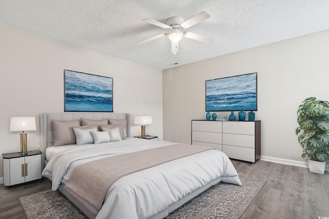 bedroom featuring ceiling fan, light hardwood / wood-style flooring, and a textured ceiling