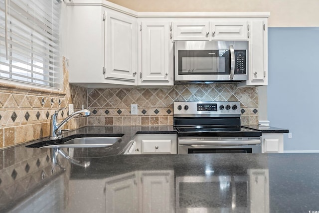 kitchen with backsplash, appliances with stainless steel finishes, sink, and white cabinets