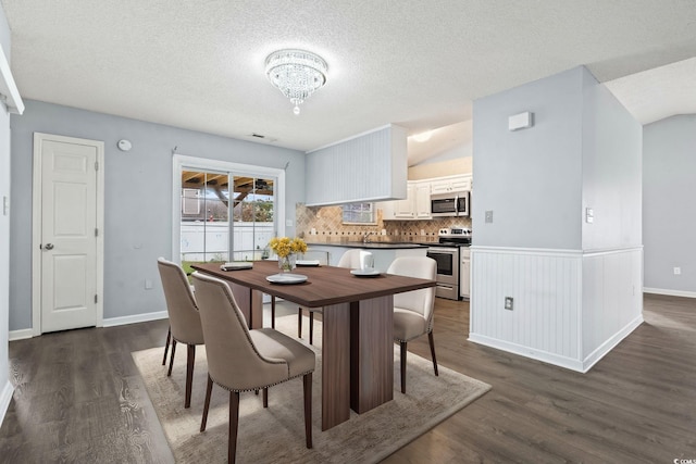 dining space featuring a notable chandelier, dark hardwood / wood-style floors, and a textured ceiling