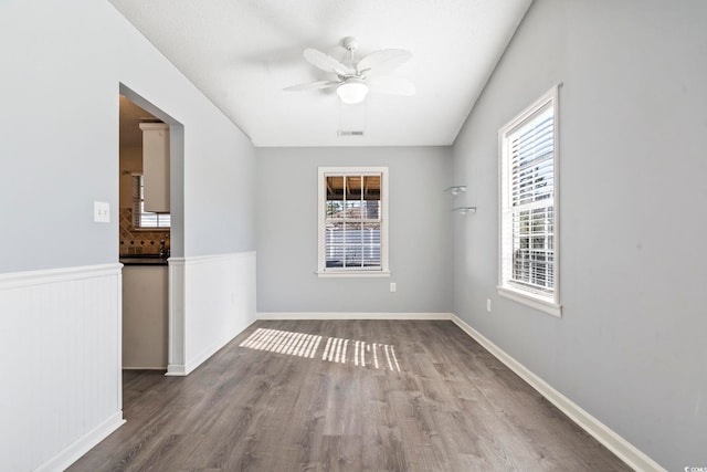 spare room with wood-type flooring, a healthy amount of sunlight, and ceiling fan