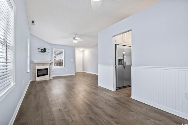 unfurnished living room with dark hardwood / wood-style floors, a fireplace, and ceiling fan