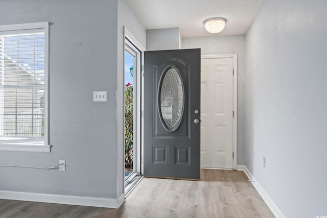 foyer entrance featuring a textured ceiling and light hardwood / wood-style flooring