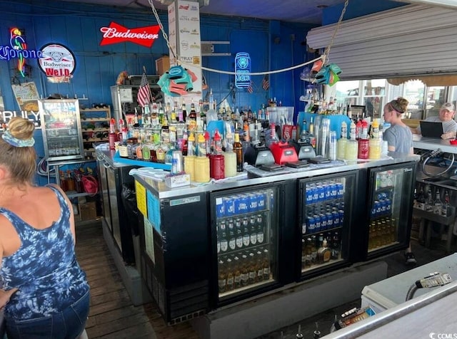 bar with hardwood / wood-style floors