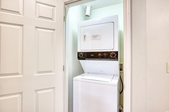 washroom with stacked washing maching and dryer