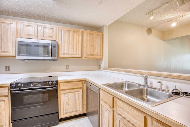 kitchen with light brown cabinetry, stainless steel appliances, and sink