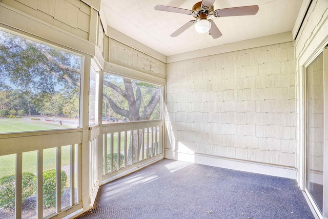 unfurnished sunroom featuring ceiling fan