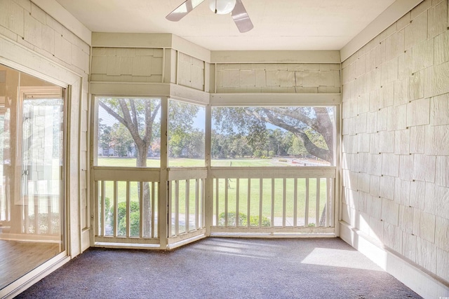 unfurnished sunroom with ceiling fan