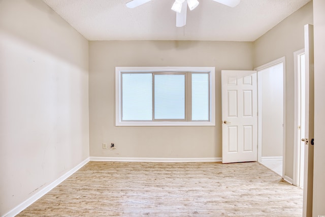 spare room featuring a textured ceiling, light wood-type flooring, and ceiling fan