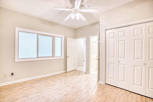 unfurnished bedroom with a closet, a textured ceiling, light hardwood / wood-style floors, and ceiling fan