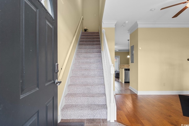 stairway with wood-type flooring and ornamental molding