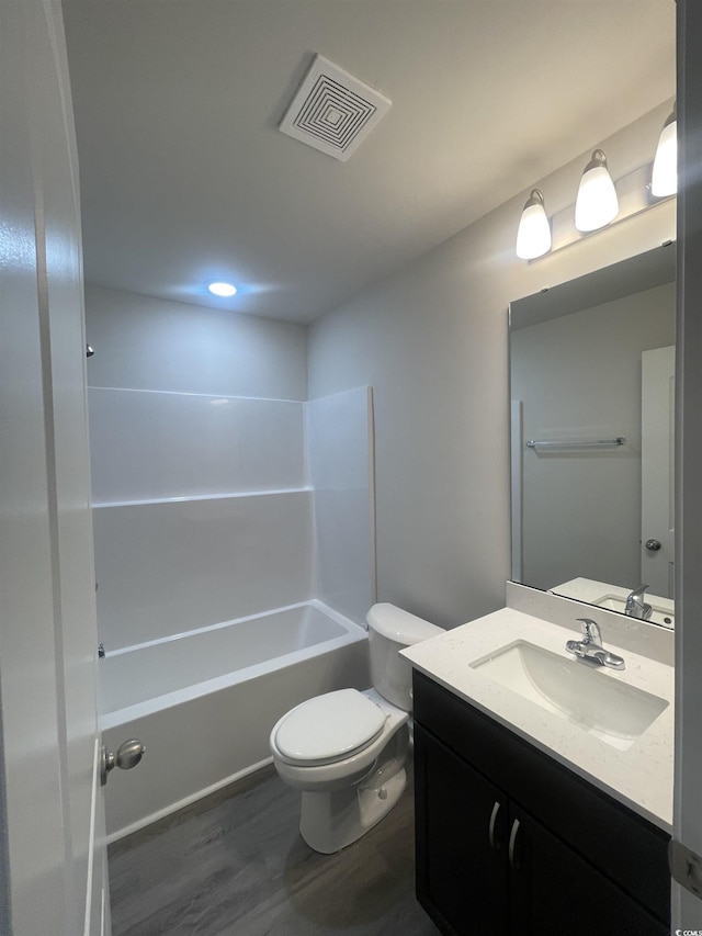 full bathroom featuring bathtub / shower combination, wood-type flooring, vanity, and toilet