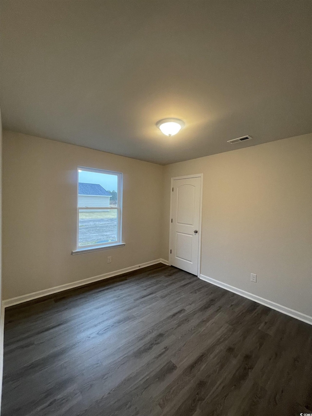 unfurnished room with dark hardwood / wood-style floors