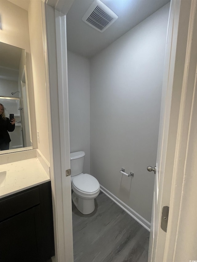 bathroom with vanity, hardwood / wood-style flooring, and toilet