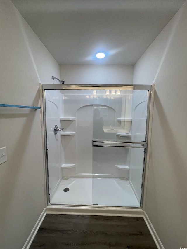 bathroom featuring hardwood / wood-style floors and a shower with door