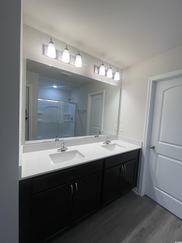 bathroom with a shower, hardwood / wood-style floors, and vanity
