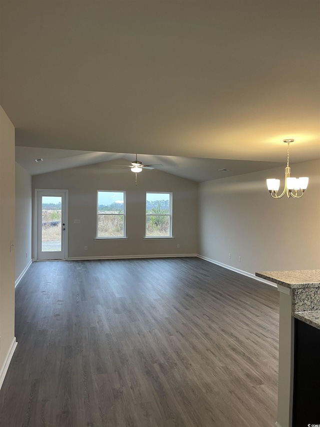 unfurnished living room with dark hardwood / wood-style flooring, ceiling fan with notable chandelier, and vaulted ceiling