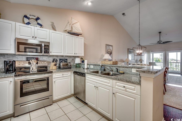 kitchen featuring kitchen peninsula, stainless steel appliances, white cabinets, and hanging light fixtures