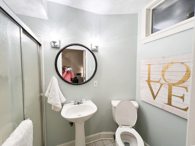 bathroom with tile patterned flooring, an enclosed shower, and toilet