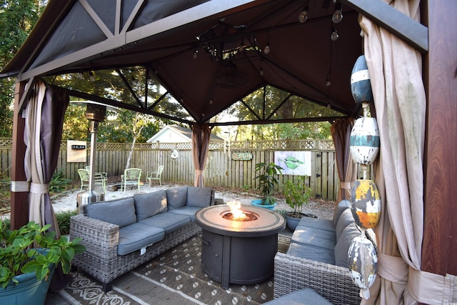 view of patio / terrace featuring a gazebo and an outdoor living space with a fire pit