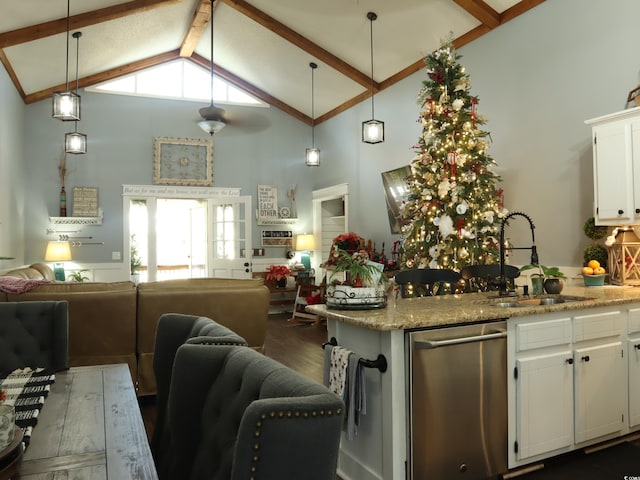 kitchen featuring light stone counters, decorative light fixtures, white cabinetry, and sink