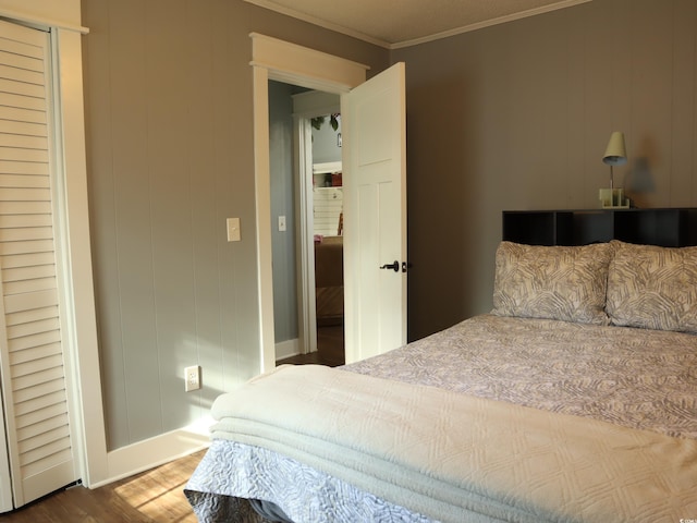 bedroom with hardwood / wood-style floors and crown molding