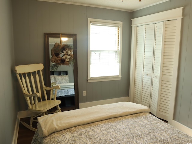 bedroom featuring wooden walls, a closet, and ornamental molding