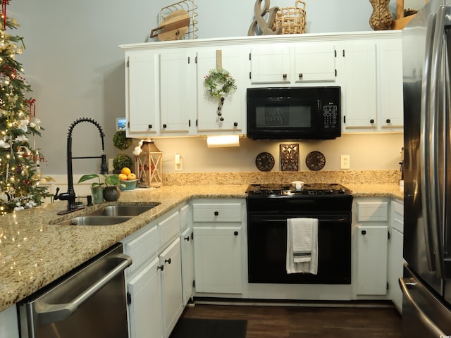 kitchen with sink, dark hardwood / wood-style floors, light stone counters, white cabinetry, and stainless steel appliances