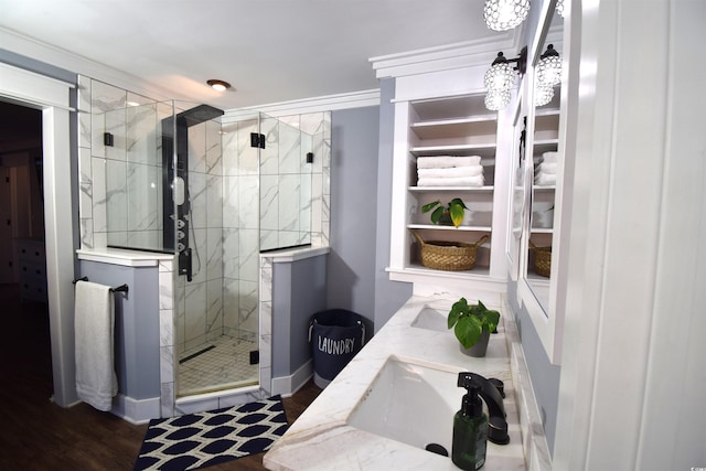 bathroom with vanity, crown molding, wood-type flooring, and a shower with door