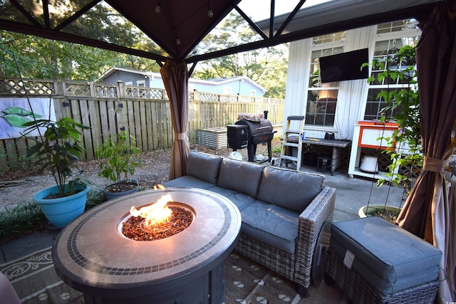 view of patio / terrace featuring a gazebo, a grill, and an outdoor living space with a fire pit