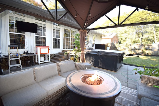 view of patio / terrace featuring a gazebo, a hot tub, and a fire pit