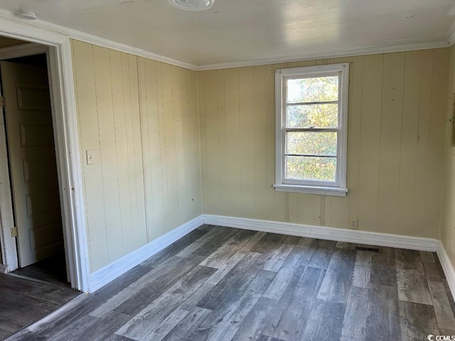 unfurnished room featuring crown molding, dark wood-type flooring, and wood walls