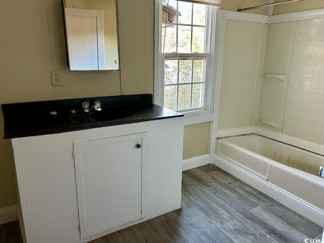 bathroom featuring hardwood / wood-style floors, vanity, and bathing tub / shower combination