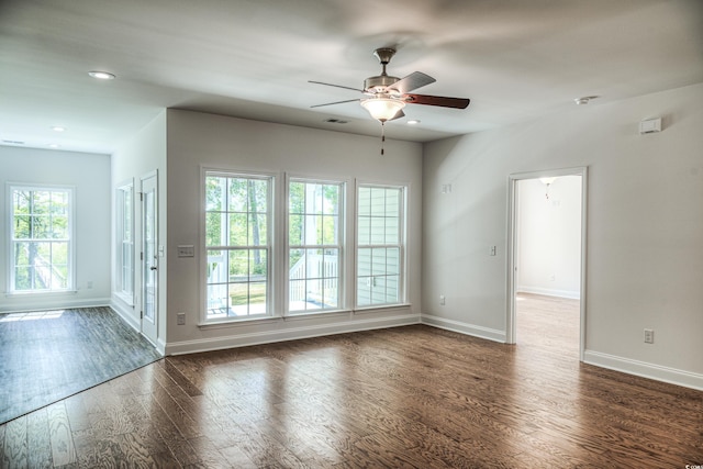 spare room featuring plenty of natural light, dark hardwood / wood-style floors, and ceiling fan