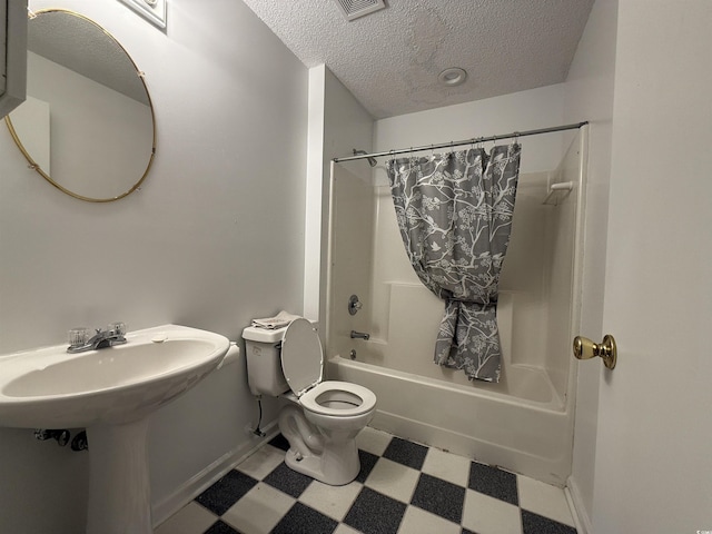 bathroom featuring a textured ceiling, shower / bath combo, and toilet