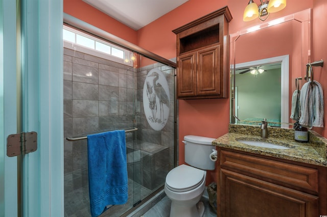 bathroom featuring vanity, a shower with door, and toilet