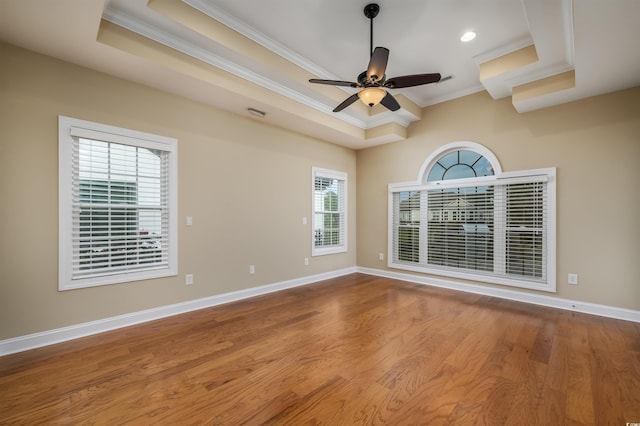 spare room with light hardwood / wood-style floors, a raised ceiling, ceiling fan, and crown molding