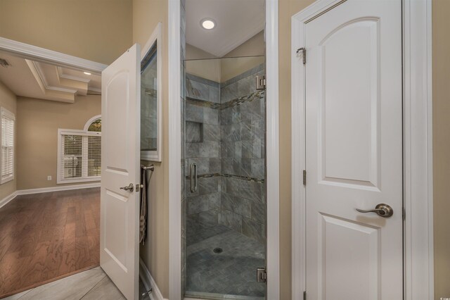 bathroom with tile patterned floors, a relaxing tiled tub, vanity, and vaulted ceiling