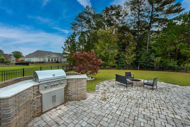 view of patio / terrace featuring exterior kitchen, a grill, and an outdoor fire pit