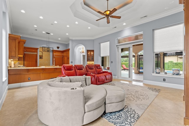 tiled living room featuring a raised ceiling, ceiling fan, and crown molding