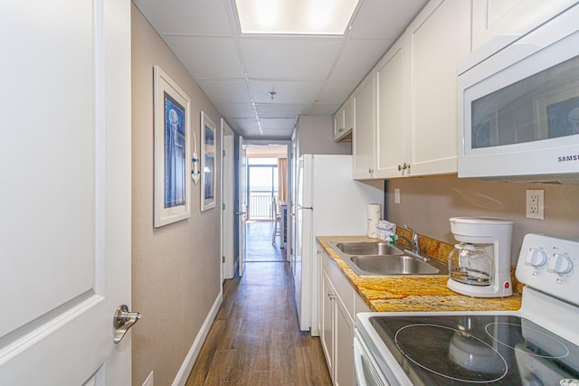 kitchen with a paneled ceiling, white appliances, sink, white cabinets, and dark hardwood / wood-style floors