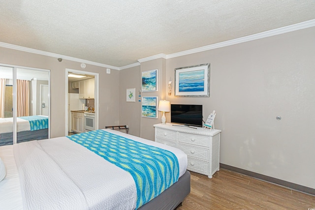 bedroom featuring a textured ceiling, light hardwood / wood-style floors, and crown molding