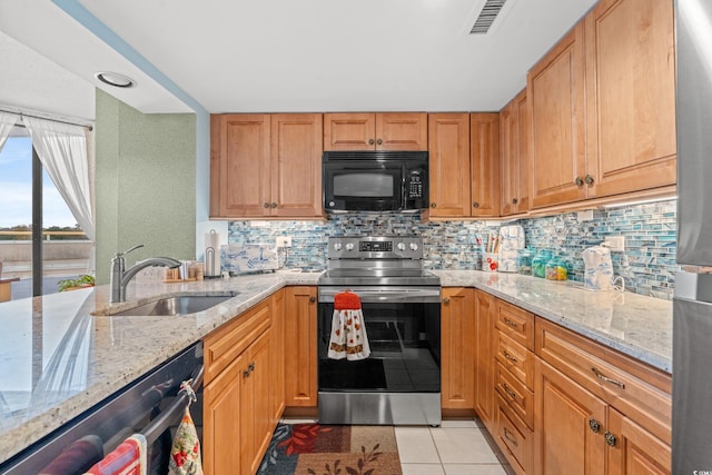 kitchen with light stone countertops, sink, backsplash, light tile patterned floors, and appliances with stainless steel finishes