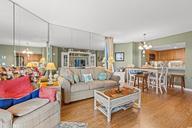 living room with light hardwood / wood-style floors and an inviting chandelier