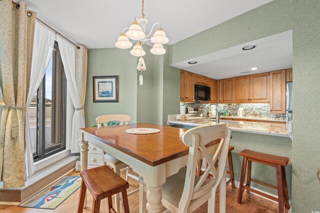 100 Ocean Creek Dr Unit L5, Myrtle Beach, SC 29572 - dining room featuring light wood-style floors, a chandelier, and a textured wall