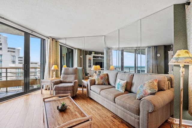 100 Ocean Creek Dr Unit L5, Myrtle Beach, SC 29572 - living area with a wall of windows, a textured ceiling, and hardwood / wood-style floors