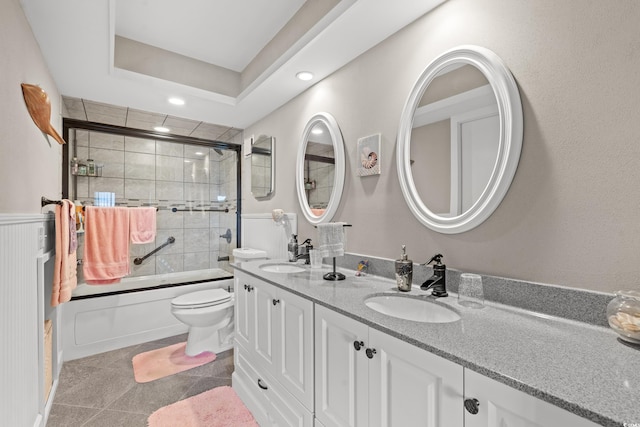 full bathroom featuring tile patterned floors, vanity, toilet, and enclosed tub / shower combo